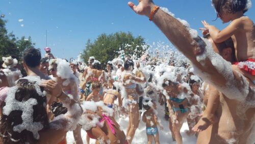 Fiesta de la espuma en Gran Canaria con niños y familias bailando en la espuma